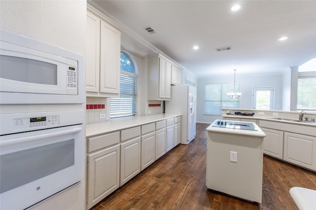 kitchen with white cabinets, dark hardwood / wood-style floors, white appliances, and sink