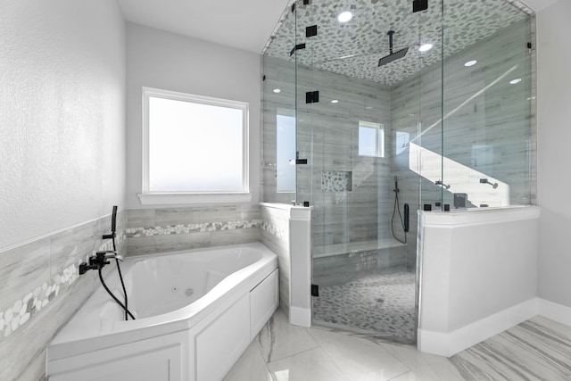 bathroom featuring tile walls and separate shower and tub