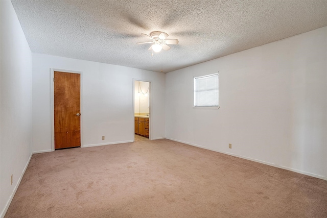 empty room featuring ceiling fan, light colored carpet, and a textured ceiling