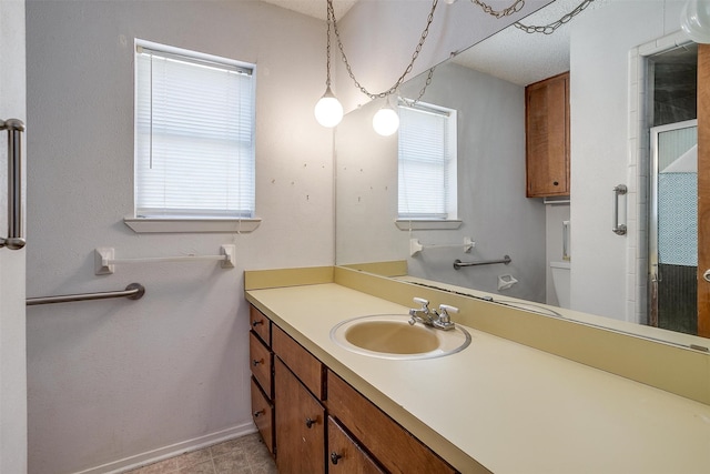 bathroom featuring vanity, a healthy amount of sunlight, tile patterned floors, and toilet