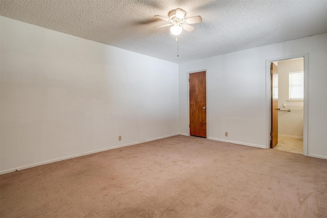 carpeted empty room with ceiling fan and a textured ceiling