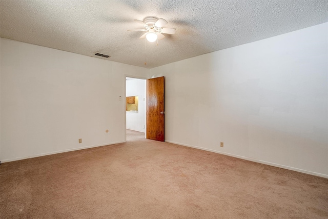 empty room with ceiling fan, light carpet, and a textured ceiling