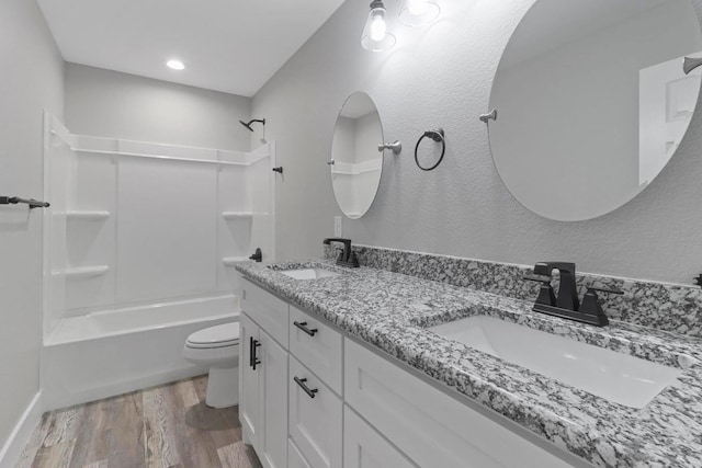 full bathroom with toilet, shower / bathing tub combination, hardwood / wood-style flooring, and vanity