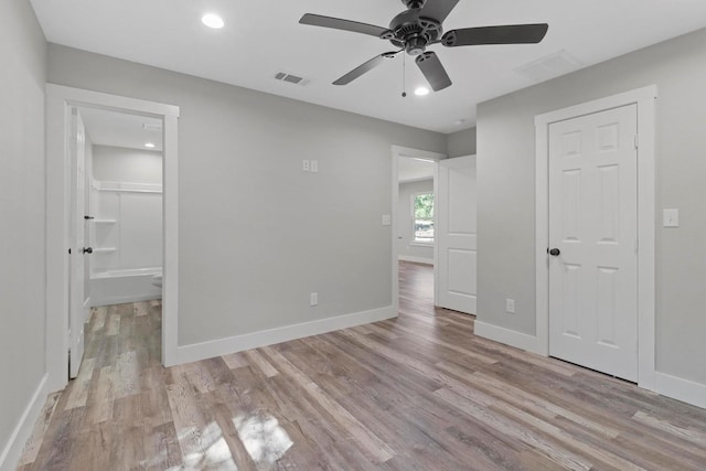 unfurnished bedroom featuring light hardwood / wood-style floors, ceiling fan, and ensuite bath