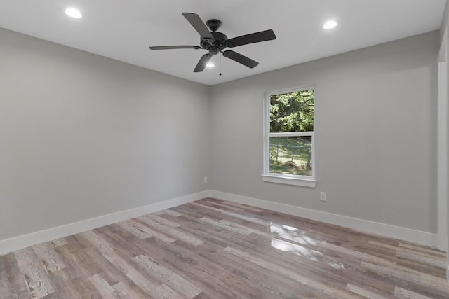 spare room with ceiling fan and light wood-type flooring