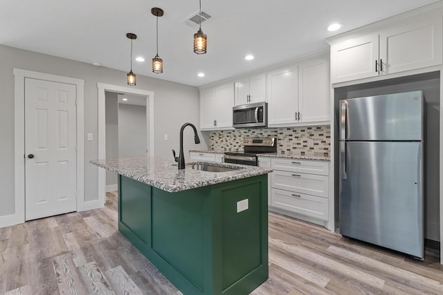 kitchen with appliances with stainless steel finishes, light hardwood / wood-style flooring, backsplash, sink, and white cabinets