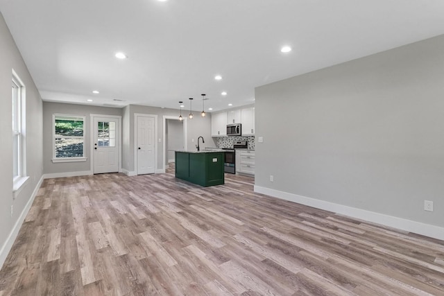 unfurnished living room with light hardwood / wood-style floors and sink