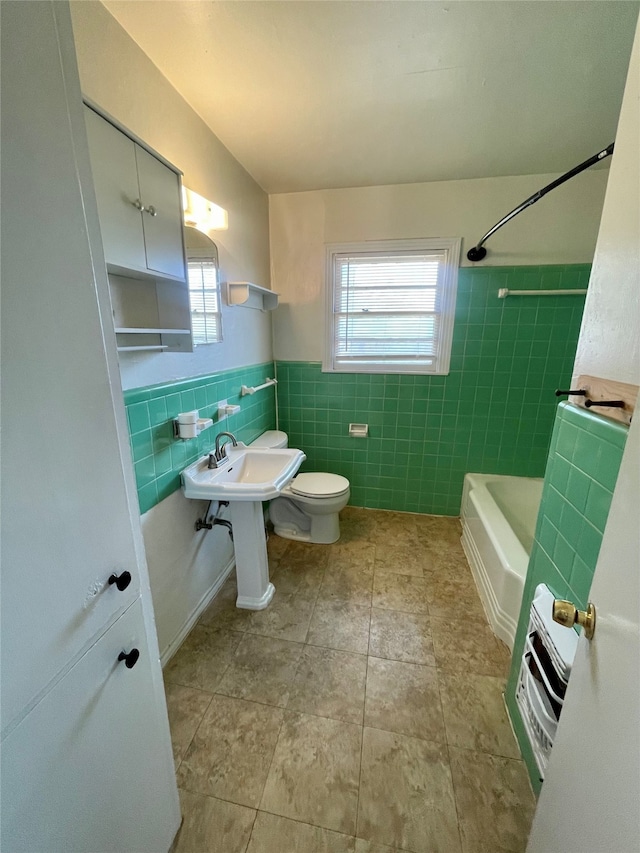 full bathroom featuring toilet, tile patterned flooring, tasteful backsplash, tile walls, and tiled shower / bath