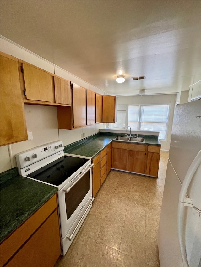 kitchen featuring sink, light tile patterned flooring, and white appliances