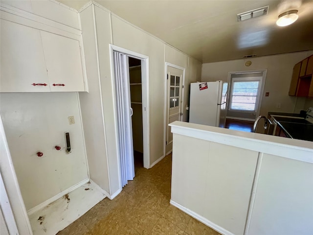 kitchen with white refrigerator, stainless steel electric range oven, and light tile patterned floors