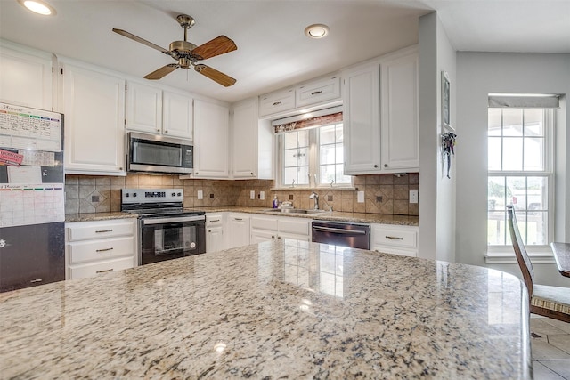 kitchen featuring backsplash, stainless steel appliances, and white cabinets