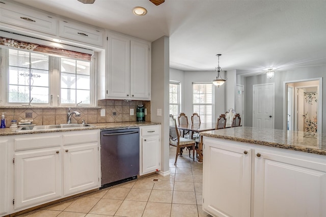 kitchen featuring white cabinets, decorative backsplash, stainless steel dishwasher, and sink