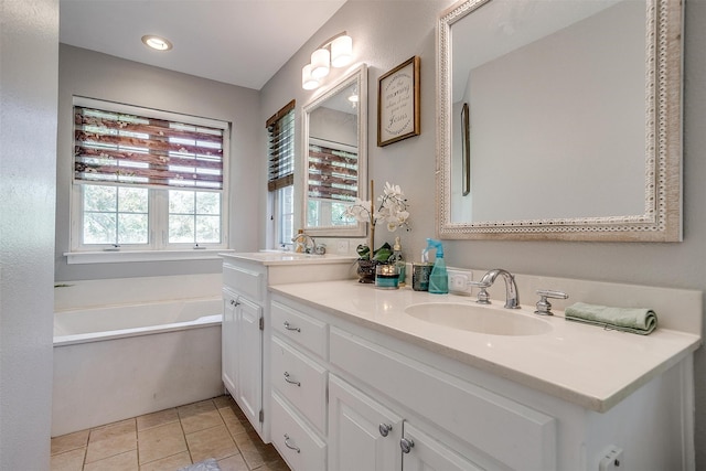 bathroom featuring tile patterned flooring, a tub, and vanity