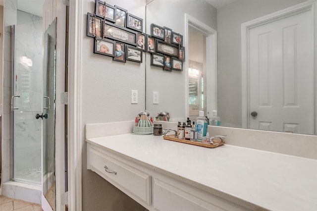 bathroom featuring tile patterned flooring, an enclosed shower, and vanity