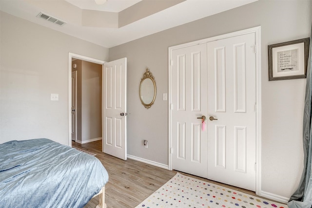 bedroom with light hardwood / wood-style flooring and a closet