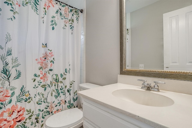 bathroom with toilet, vanity, and curtained shower