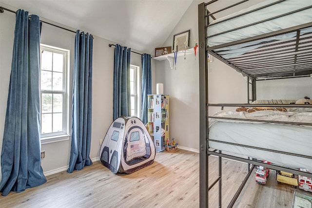 bedroom featuring vaulted ceiling and light wood-type flooring