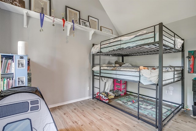 bedroom with lofted ceiling and light wood-type flooring