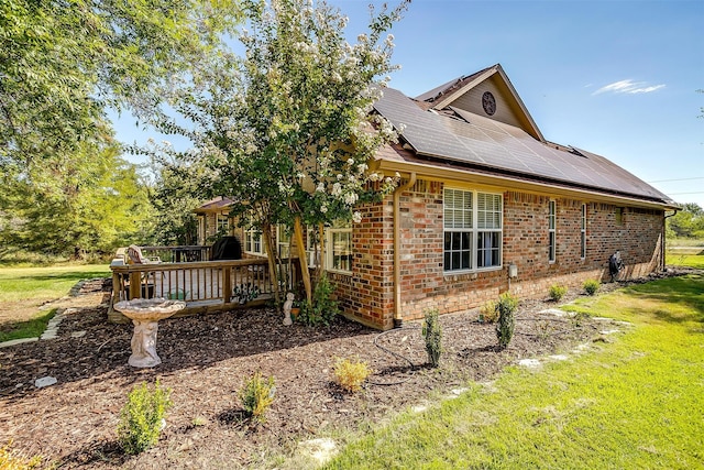 view of side of property with a yard and solar panels