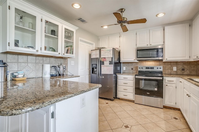 kitchen featuring white cabinetry, appliances with stainless steel finishes, decorative backsplash, and ceiling fan