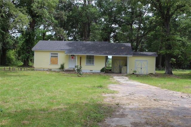 929 Forsythe St, Carthage, TX 75633 - ranch-style home with an outdoor structure, aphalt driveway, a shed, and a front lawn