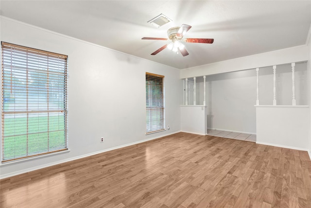 spare room featuring visible vents, a ceiling fan, crown molding, and light wood-type flooring