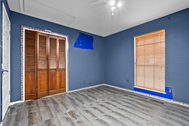 unfurnished bedroom featuring ceiling fan, a closet, and hardwood / wood-style floors