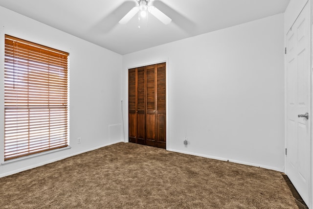 unfurnished bedroom featuring ceiling fan, a closet, and carpet