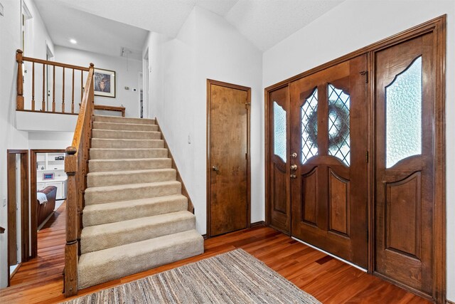 entryway featuring hardwood / wood-style flooring and vaulted ceiling