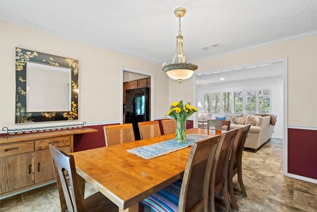 tiled dining area featuring a textured ceiling and ornamental molding