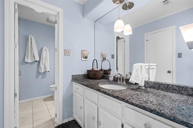 bathroom featuring toilet, tile patterned flooring, vanity, and ornamental molding