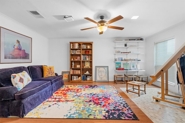 living room featuring light hardwood / wood-style floors, crown molding, and ceiling fan