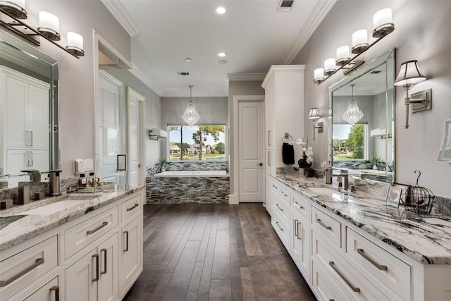 bathroom with ornamental molding, two vanities, and a sink