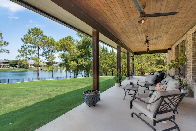 view of patio featuring ceiling fan, a water view, and fence