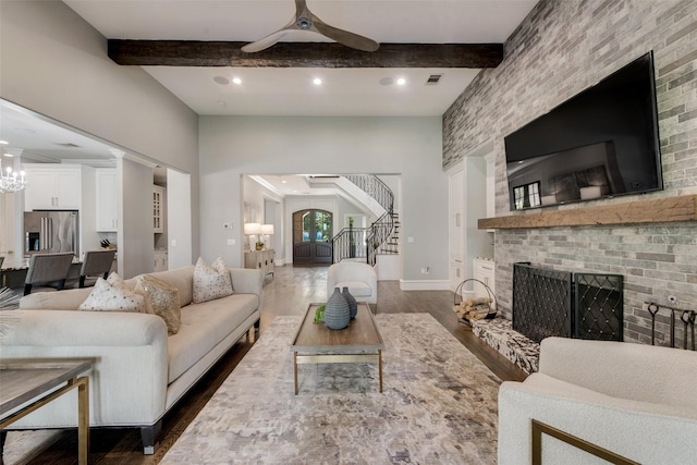 living room with visible vents, dark wood-style floors, beamed ceiling, stairs, and a fireplace