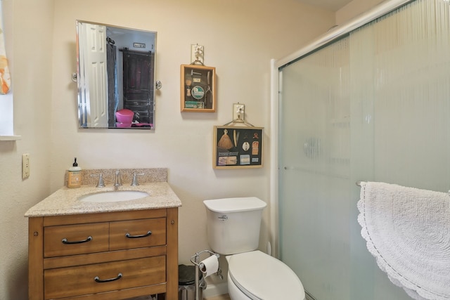 bathroom featuring an enclosed shower, toilet, and vanity