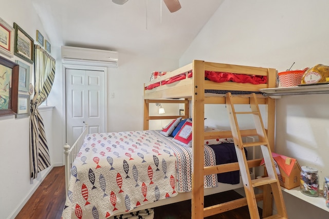 bedroom with ceiling fan, a closet, hardwood / wood-style flooring, a wall mounted AC, and lofted ceiling