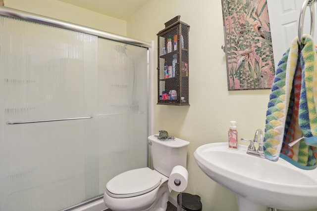 bathroom featuring sink, an enclosed shower, and toilet