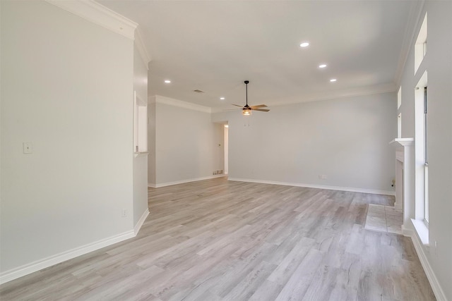 unfurnished room featuring a fireplace, a ceiling fan, light wood-style floors, baseboards, and crown molding