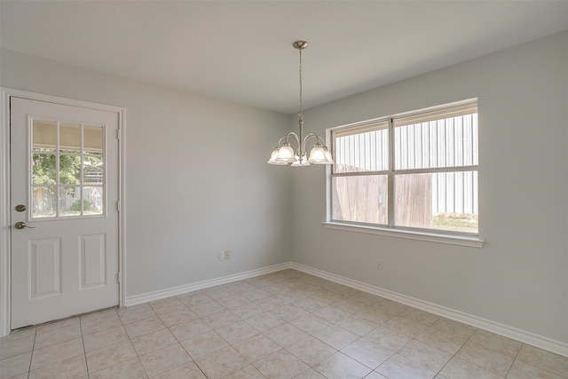 spare room with baseboards, light tile patterned floors, and an inviting chandelier