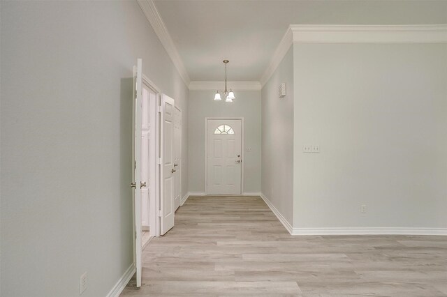 entryway featuring a notable chandelier, light hardwood / wood-style floors, and crown molding