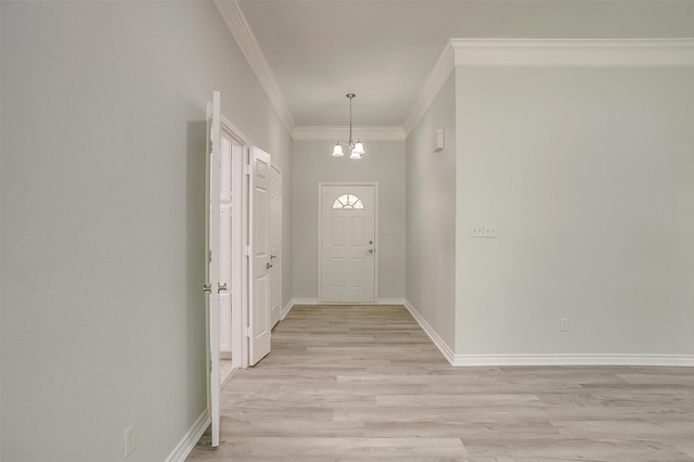 entrance foyer featuring a chandelier, light wood-type flooring, crown molding, and baseboards