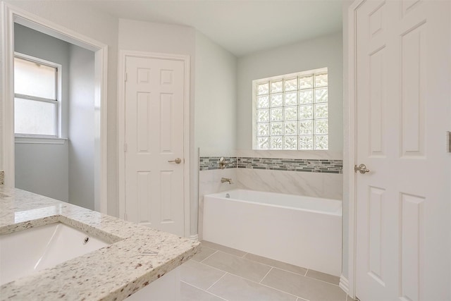 bathroom featuring vanity, a bath, and tile patterned floors