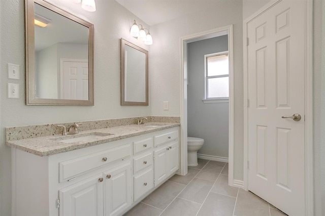 bathroom featuring tile patterned flooring, a sink, toilet, and double vanity