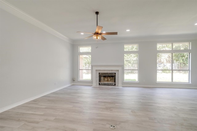 unfurnished living room featuring recessed lighting, a high end fireplace, baseboards, ornamental molding, and light wood finished floors