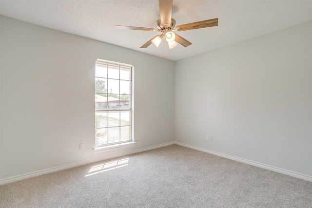 unfurnished room with a textured ceiling, carpet floors, ceiling fan, and baseboards