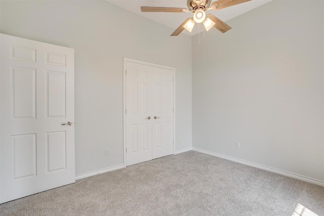 unfurnished bedroom with baseboards, ceiling fan, a closet, and light colored carpet