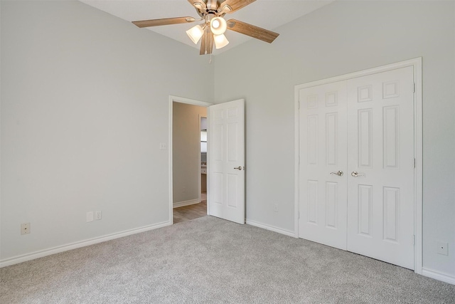 unfurnished bedroom with light carpet, a ceiling fan, baseboards, and a closet