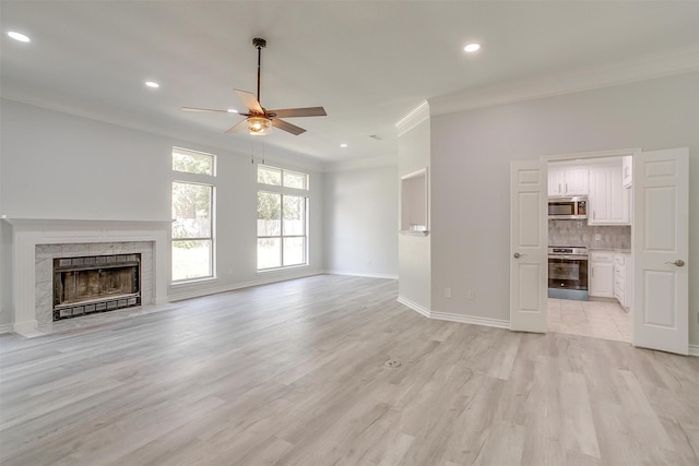 unfurnished living room with ornamental molding, recessed lighting, light wood-style floors, and baseboards