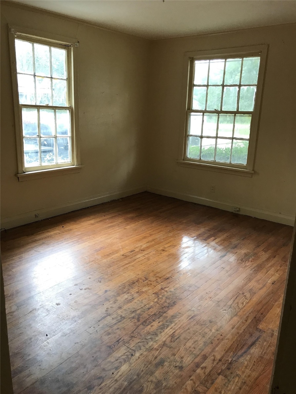 unfurnished room with hardwood / wood-style flooring and a healthy amount of sunlight